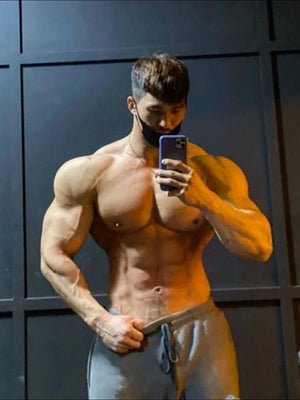 Gray jersey shorts with drawstring waist and pockets, worn by a man taking a mirror selfie.
