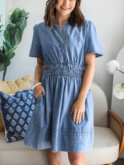 Chic denim dress with notched neckline, short sleeves, elastic waist, and A-line skirt.