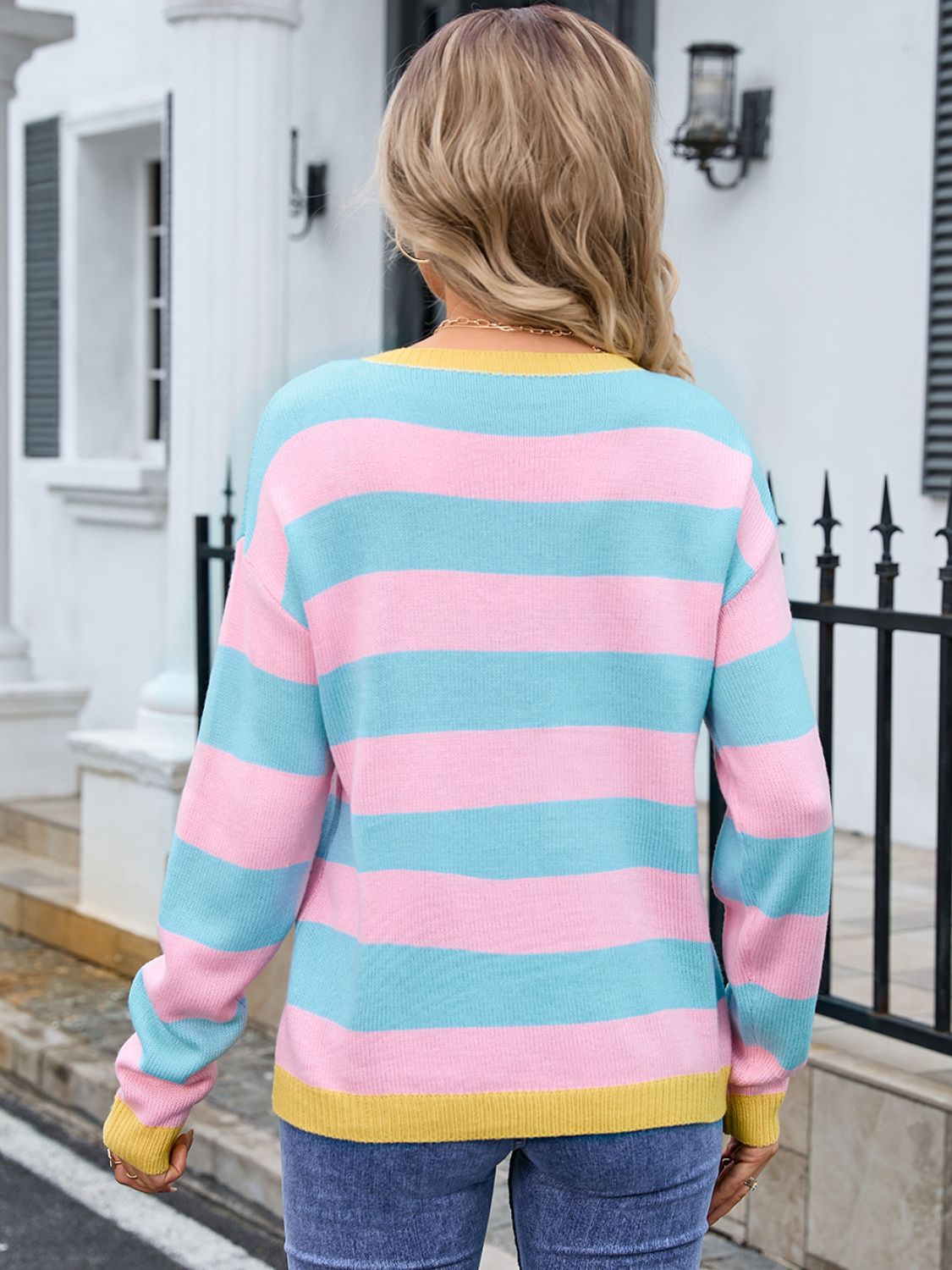 Sweater with pink, blue, and yellow stripes, crew neck, long sleeves, and ribbed cuffs.