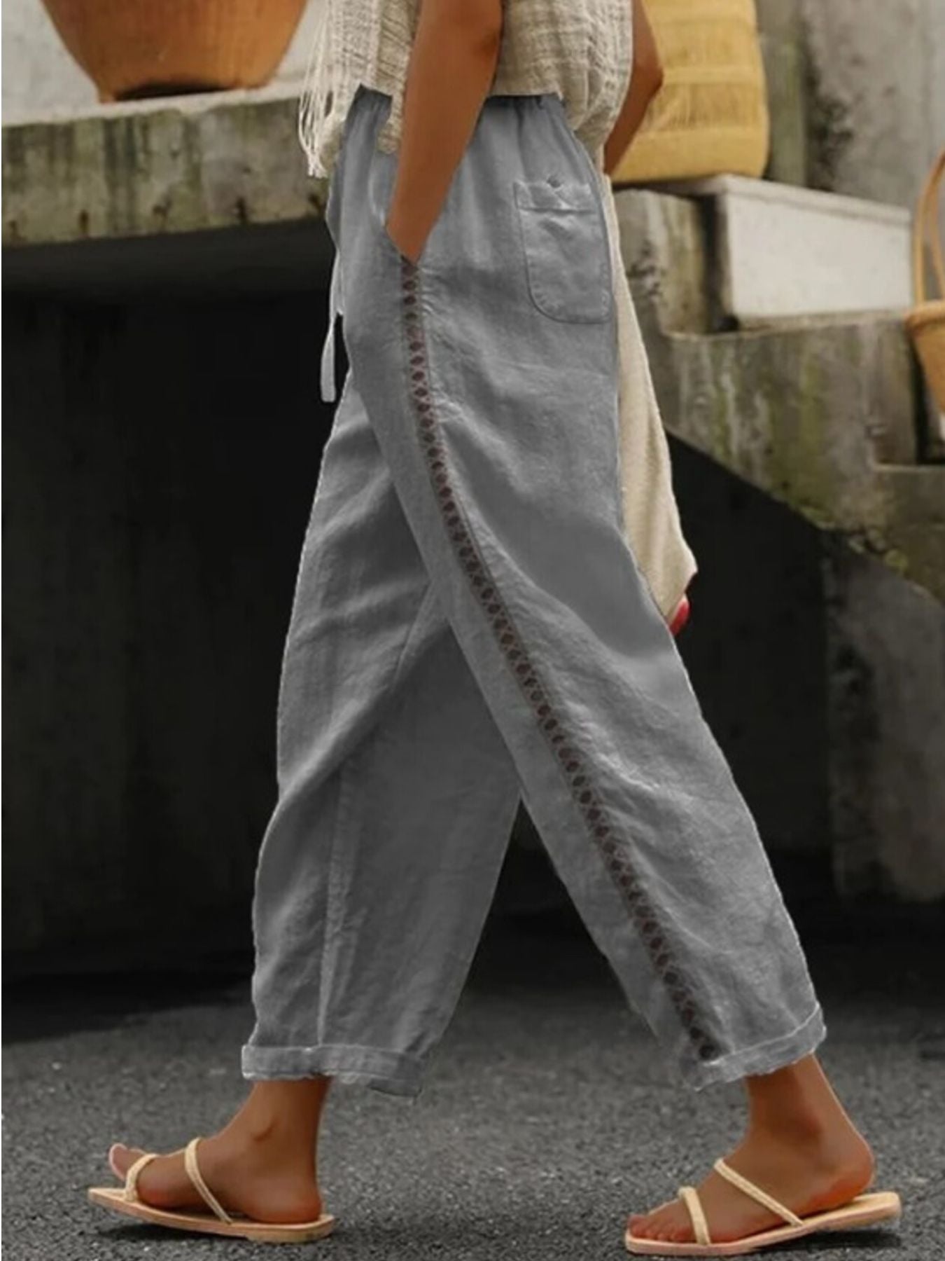 Grey relaxed cropped pants with hollow out trim detail and drawstring waist.