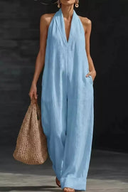 Light blue halter neck pocketed jumpsuit with wide legs and a deep V-neck.