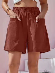 Relaxed fit utility shorts in burgundy with elastic waist and large front pockets.