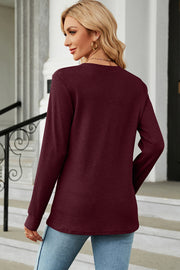 Burgundy waffle knit henley shirt with button placket and long sleeves.