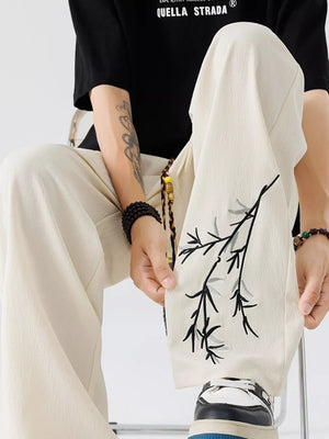 Beige embroidered wide-leg men's sweatpants with a branch design.