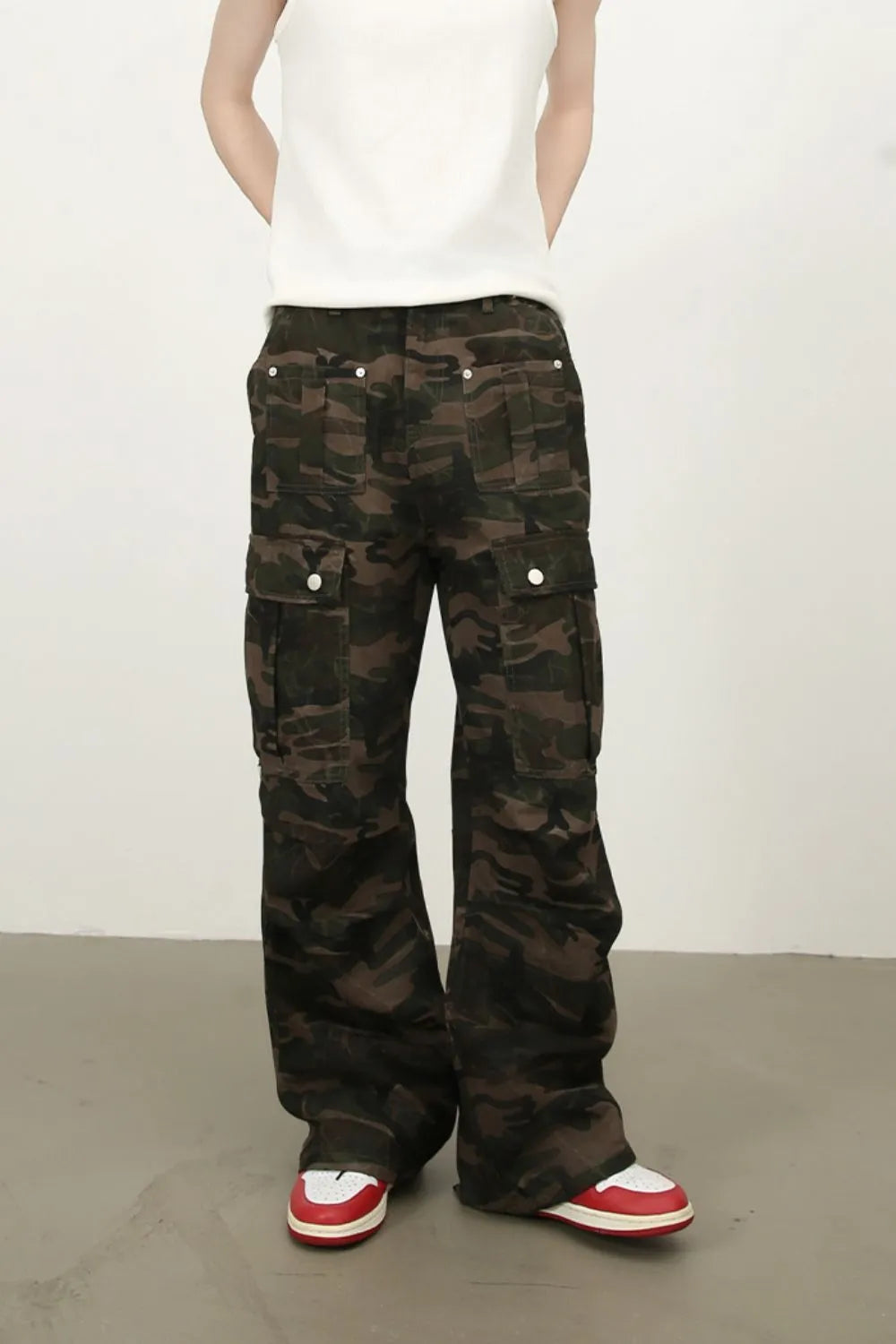 Wide-leg camo cargo trousers in green camouflage with multiple utility pockets.