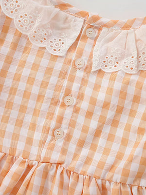 Baby dress with orange gingham pattern, lace collar, and ruffle hem.