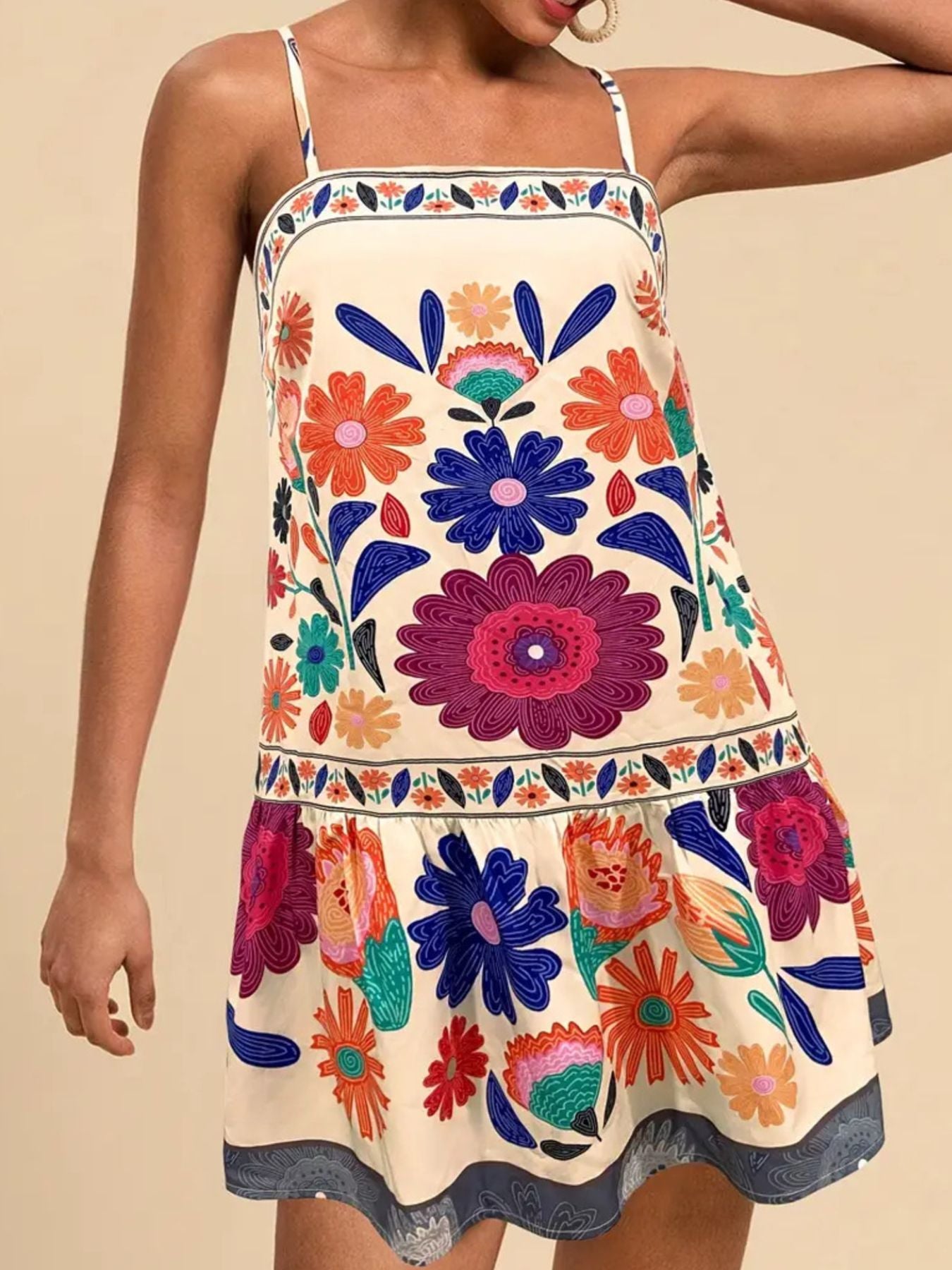 Vibrant floral print mini dress with spaghetti straps and a tiered hem.
