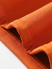 Orange long sleeve tee with crew neck and visible pocket detail.