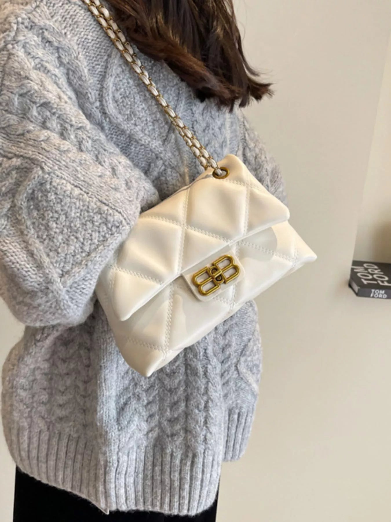 White quilted flap chain shoulder bag with gold hardware and a crossbody strap.