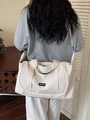Off-white nylon travel duffle bag with curved stitching and adjustable strap.