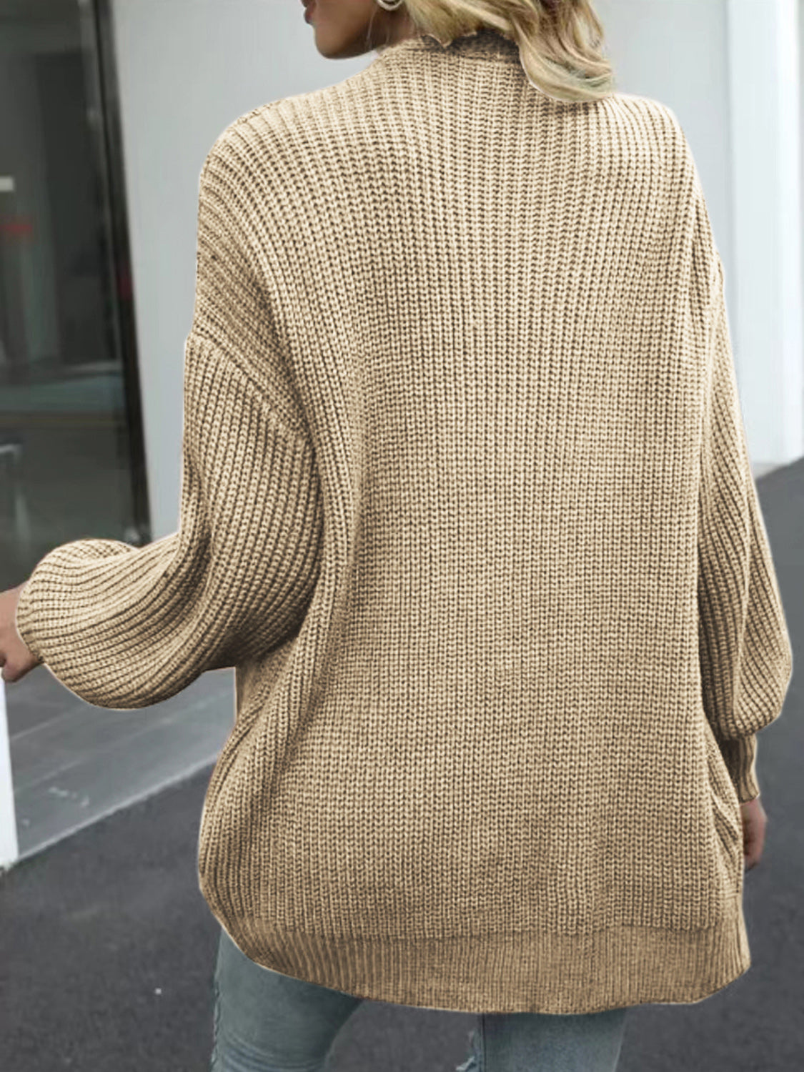 Tan chunky knit cocoon cardigan with balloon sleeves and ribbed texture.
