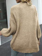 Tan chunky knit cocoon cardigan with balloon sleeves and ribbed texture.