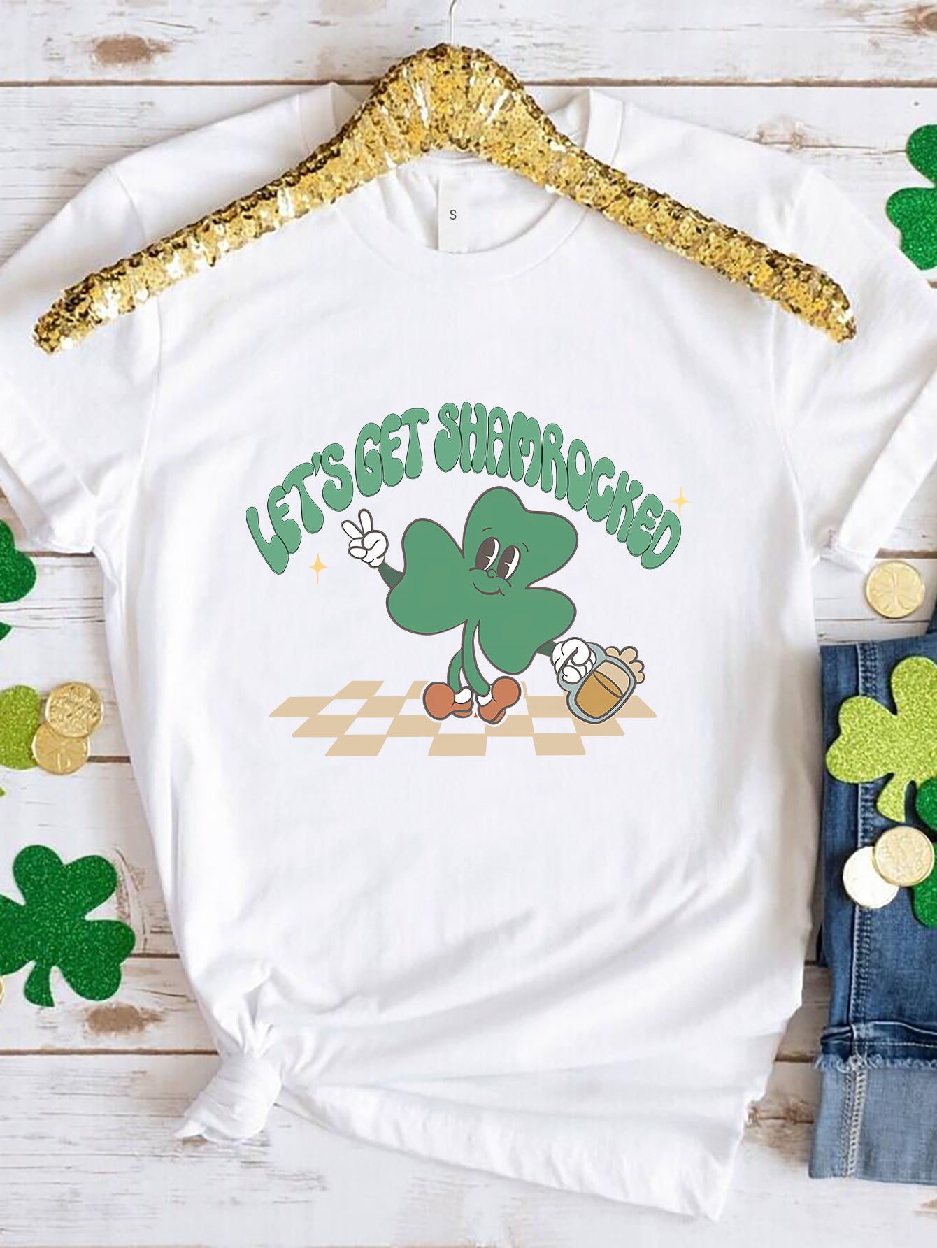 White graphic t-shirt with a retro shamrock character holding a beer and text that says Let's Get Shamrocked.