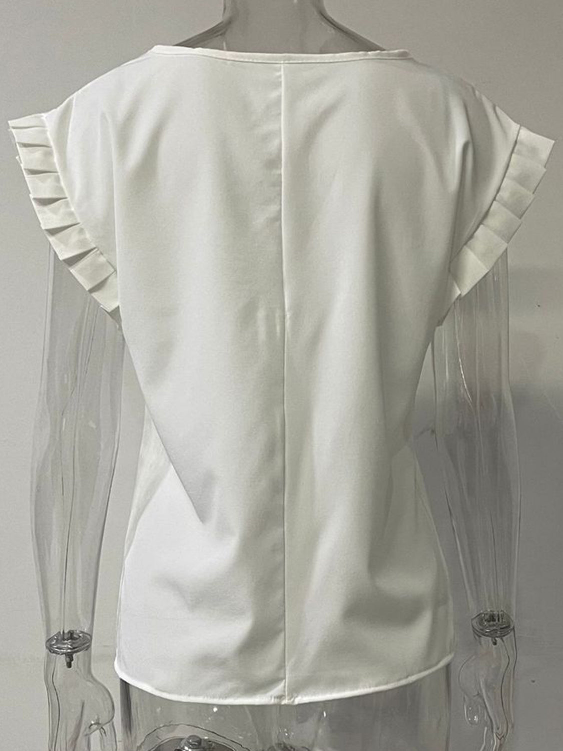 White cap-sleeve blouse with pleated sleeve details and a seam down the back.