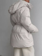 Thick puffer trench coat in ivory white with hood and belted waist.