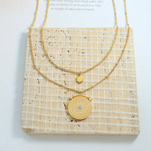 Gold layered necklace with celestial medallion and sun charm