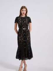 Black lace mermaid dress with short sleeves, pearl neckline, and jeweled bow belt.