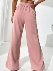 Blush pink palazzo sweatpants with V-waistline and center seams.