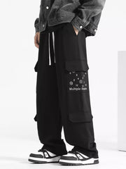 Black drawstring cargo sweatpants with multiple pockets and graphic detail.