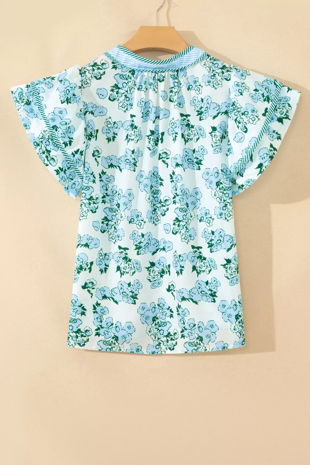Floral print polyester blouse with flutter sleeves and ruffled neckline detail.