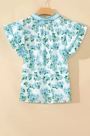 Floral print polyester blouse with flutter sleeves and ruffled neckline detail.