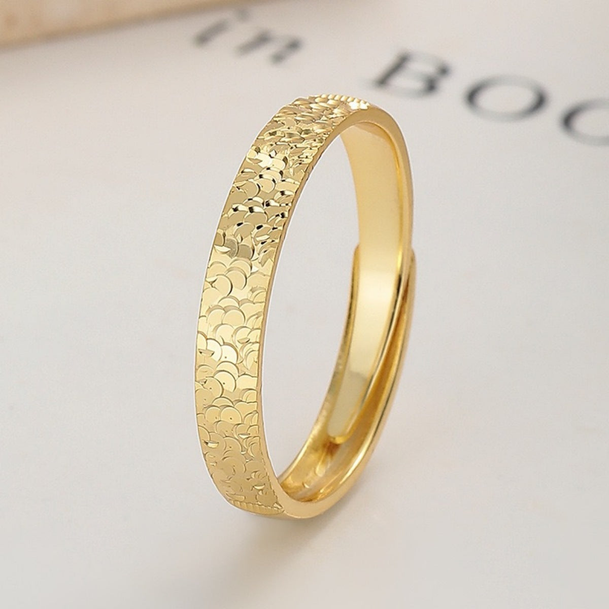 Gold textured sterling ring with adjustable band and intricate pattern detail.