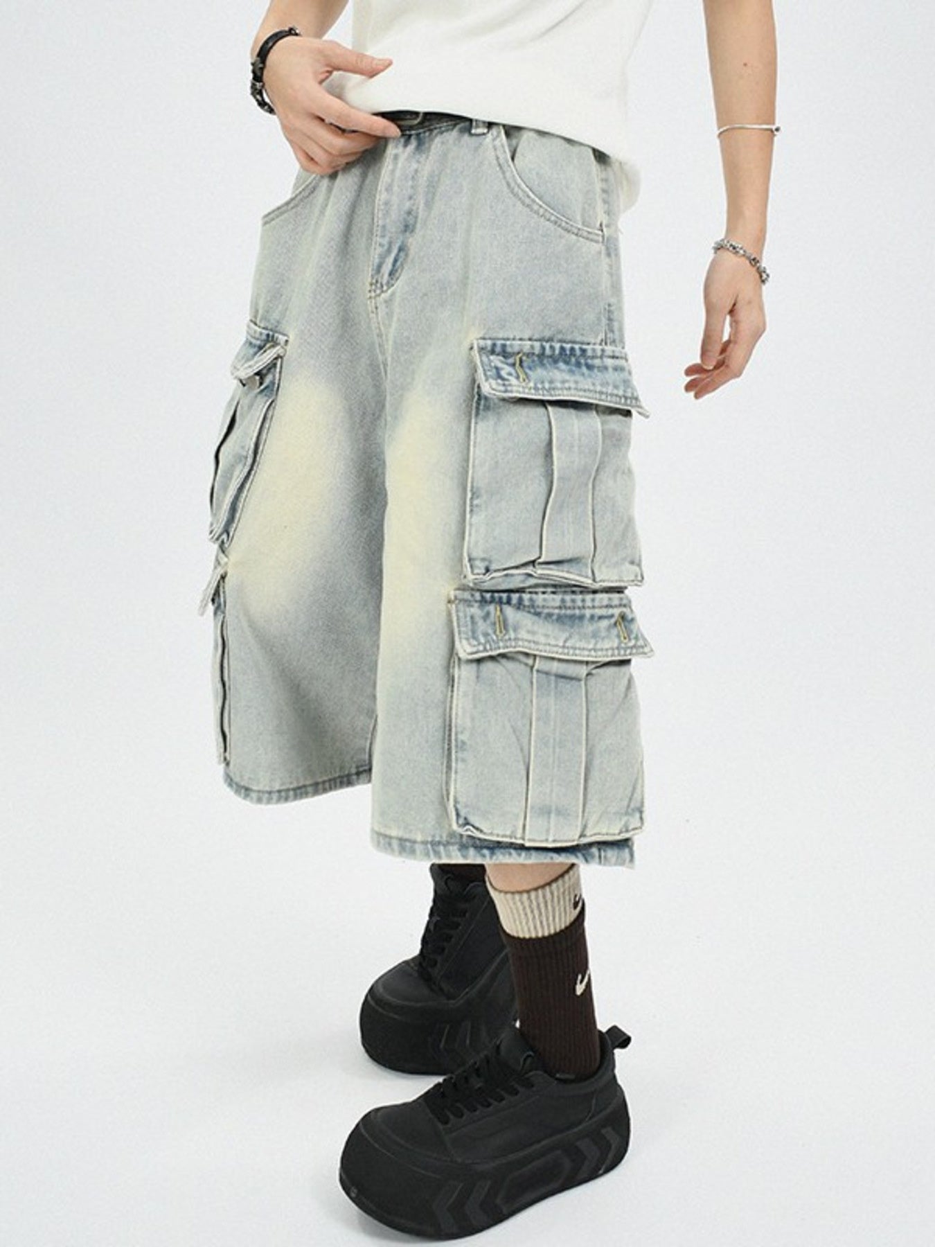 Men's light wash denim capri cargo pants with multiple pockets.