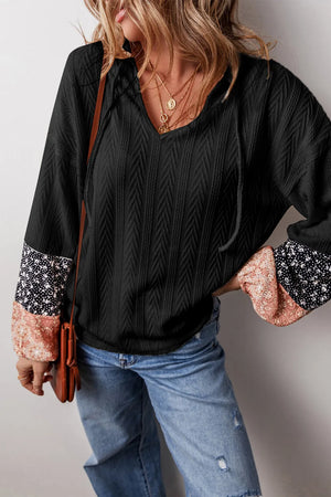 Black textured henley blouse with contrast floral print sleeves and v-neck