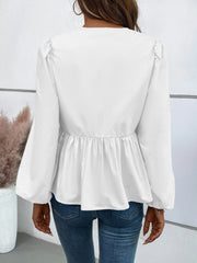 White peplum blouse with gathered puff sleeves and ruched waist detail.