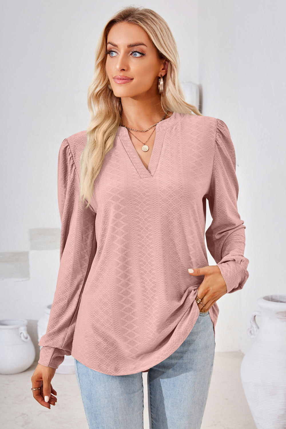 Pink textured bishop sleeve blouse with v-neck and puffed shoulders