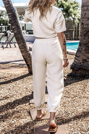 White quilted knit crop top and jogger set with short sleeves and elastic waistband.