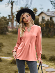 Peach pleated yoke blouse with shirred cuffs and V-neck.