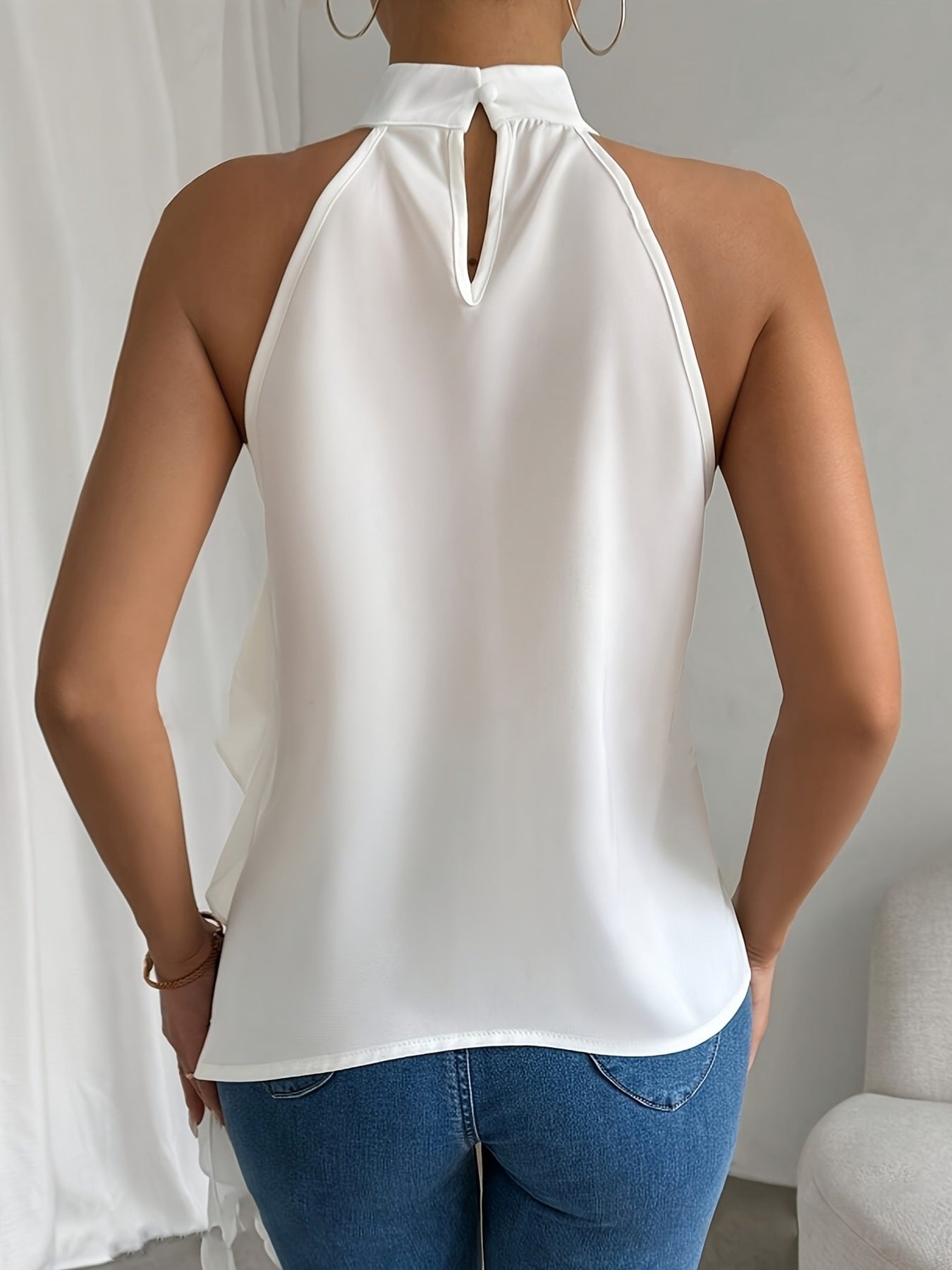 White ruffled halter neck blouse with keyhole detail and flowy back.