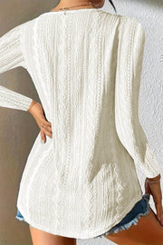 White textured diamond-stitch button-down blouse with long sleeves.
