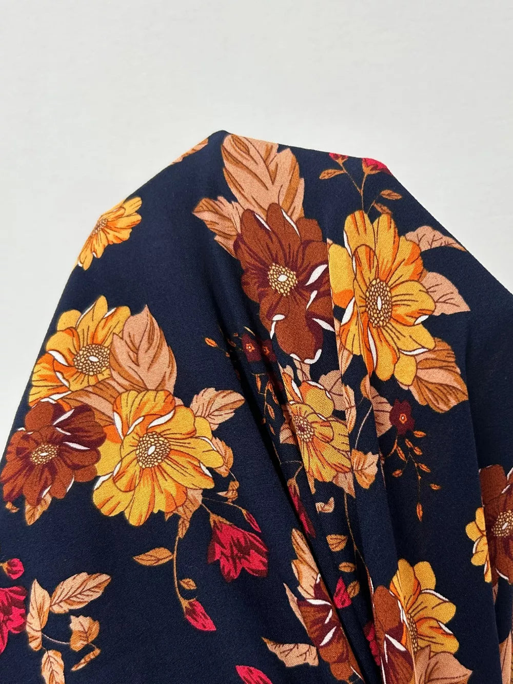 Maxi dress with a dark floral print featuring yellow, orange, and brown blooms.