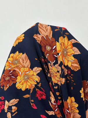 Maxi dress with a dark floral print featuring yellow, orange, and brown blooms.