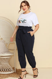 Paperbag waist lounge pants in navy with a tie belt and cuffed ankles.