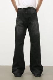 Dark wash denim trousers with exaggerated flare legs and a 70s style.