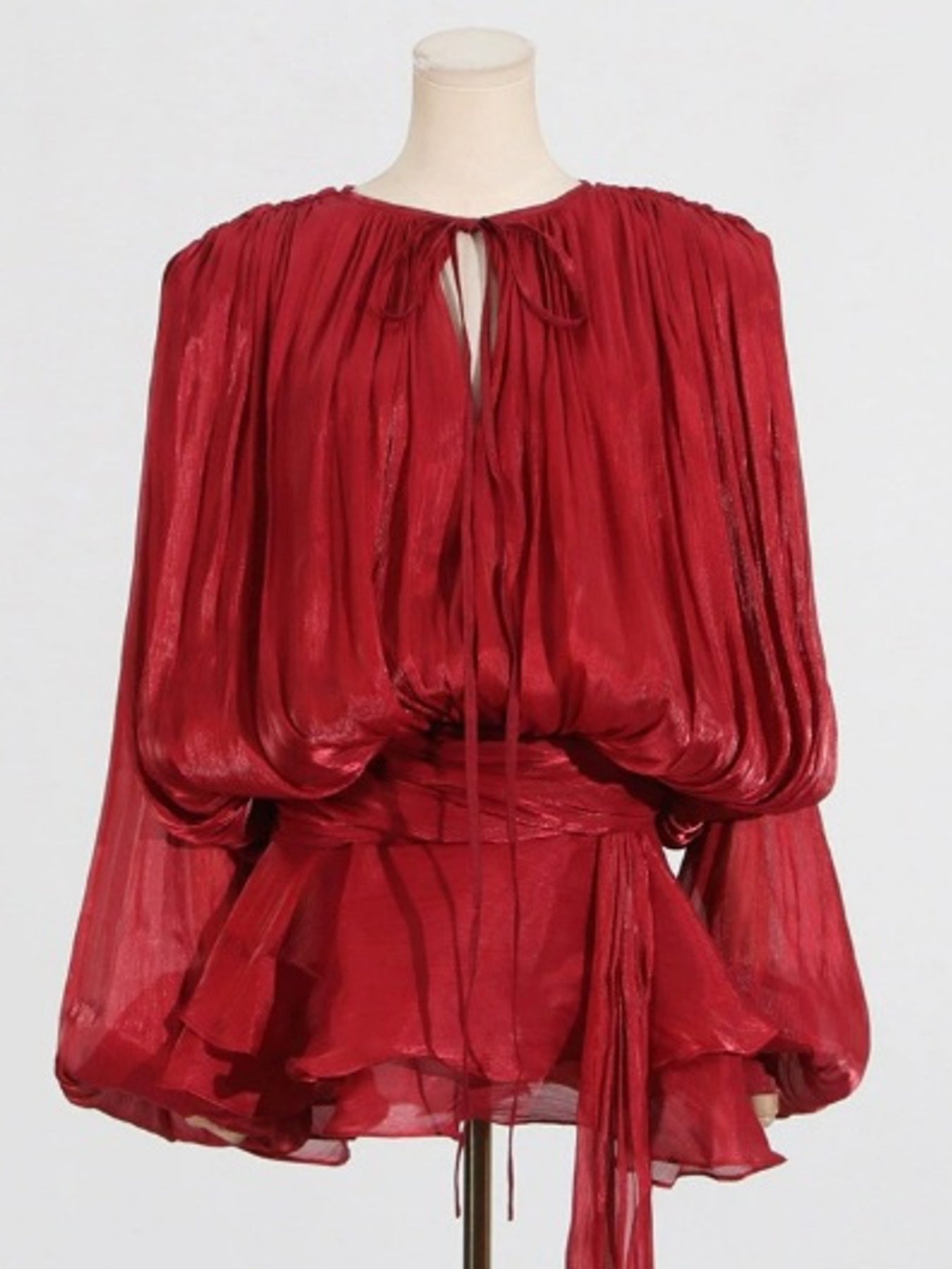 Red two-piece set with tie-neck, balloon sleeves, and tiered peplum skirt.