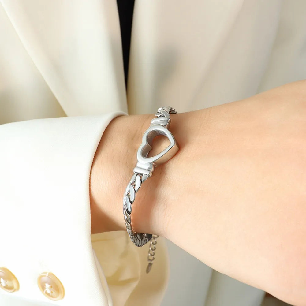 Silver curb chain bracelet with a hollow heart charm, 18K gold-plated.