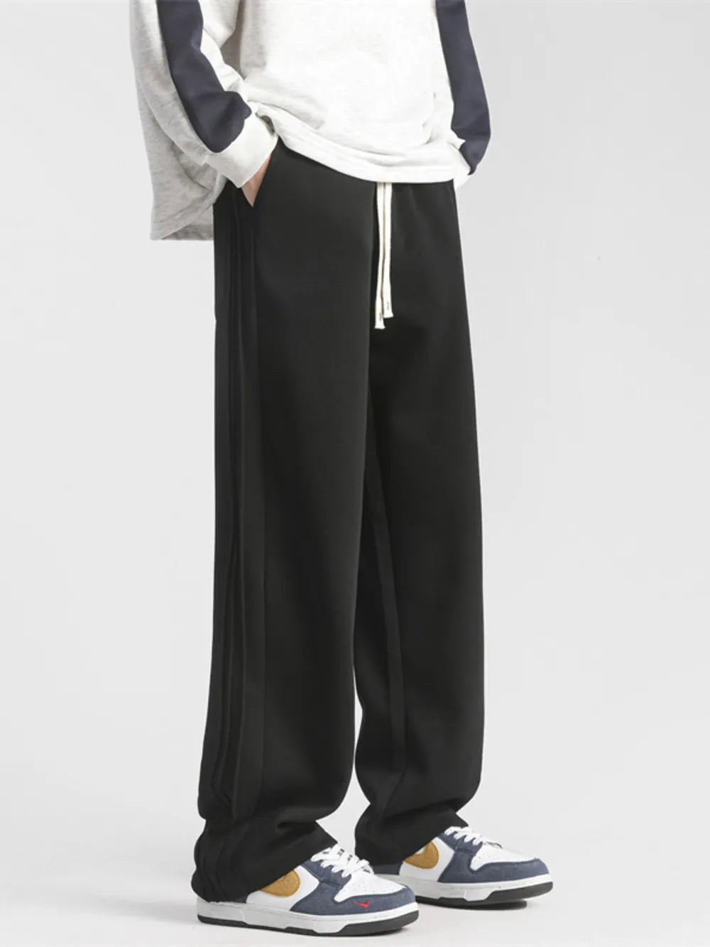 Black loose-fit sweatpants with drawstring and side stripe detail.