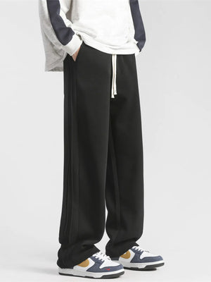 Black loose-fit sweatpants with drawstring and side stripe detail.