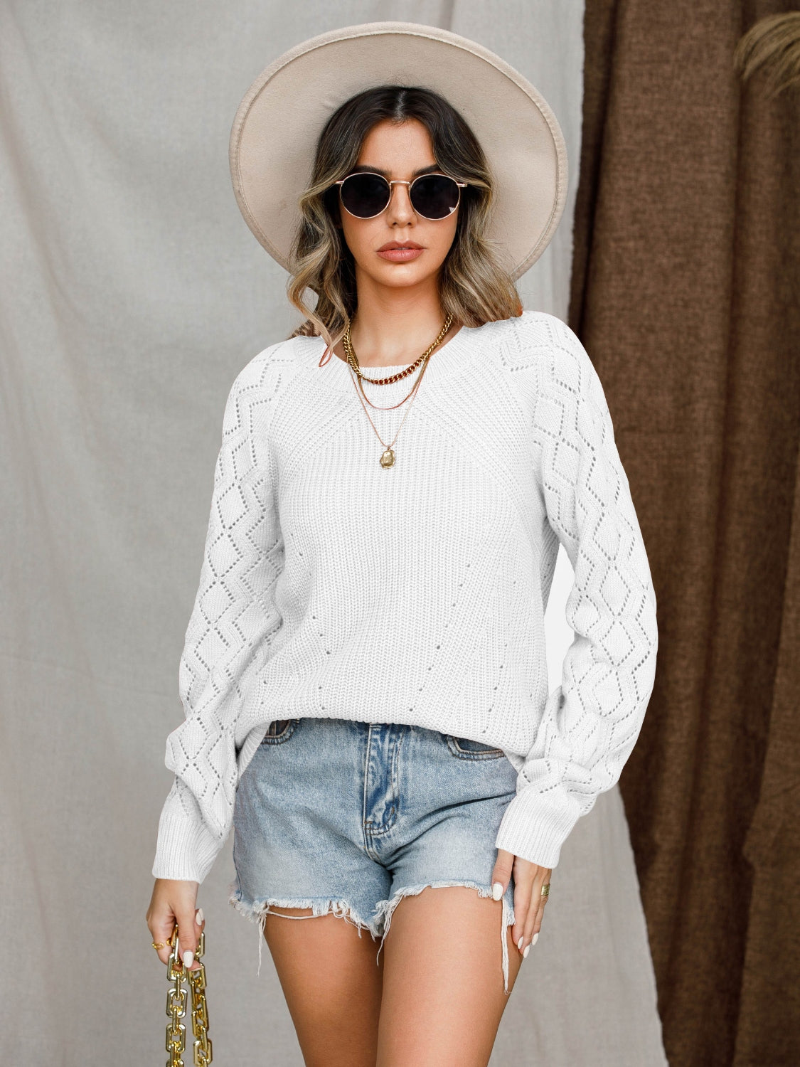White diamond-cut raglan knit sweater with textured sleeves.