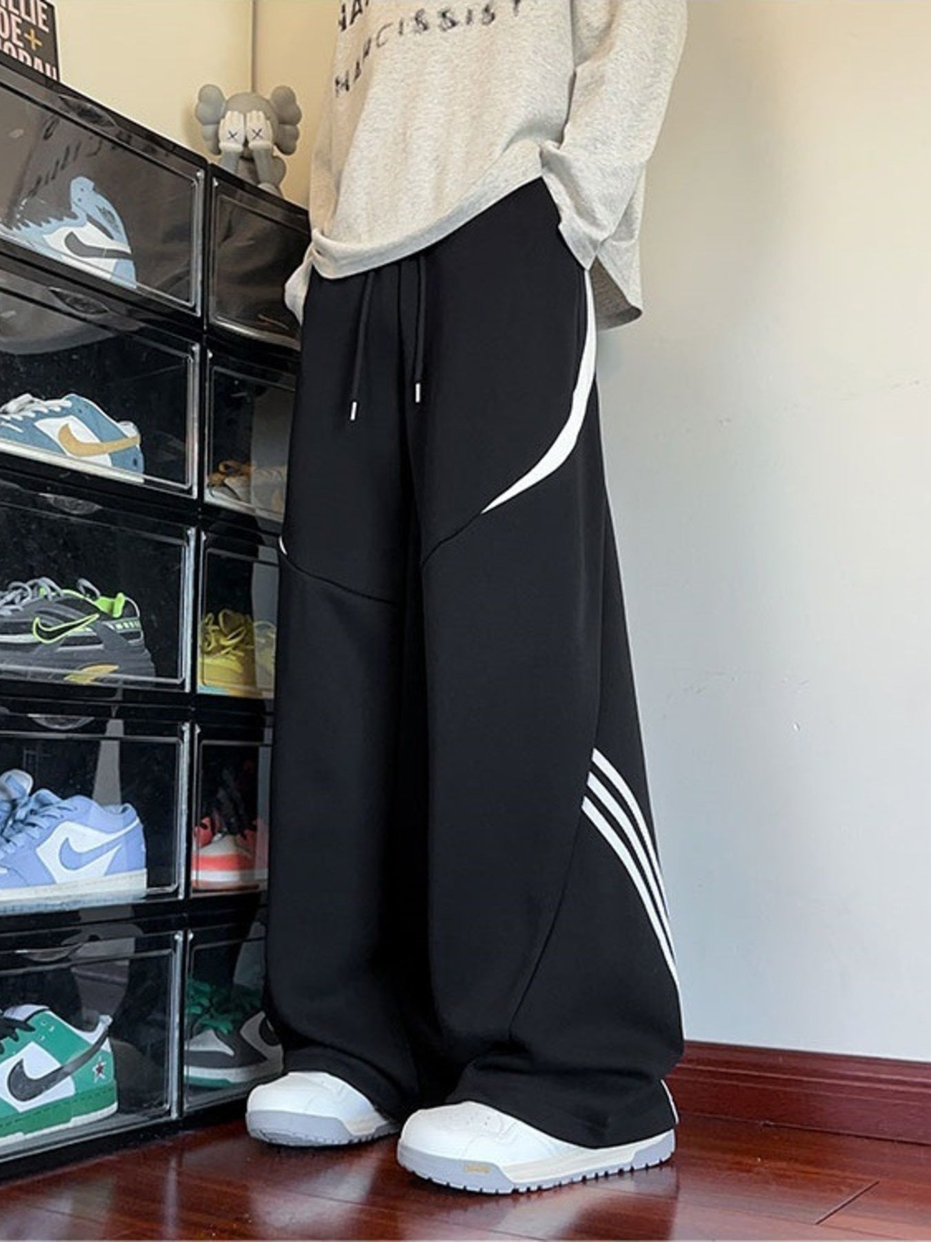Black wide-leg sweatpants with white stripe details and drawstring waist.
