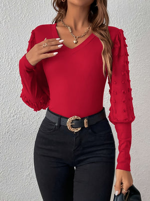 Deep Red ribbed bodysuit with V-neck and textured pom-pom sleeves.