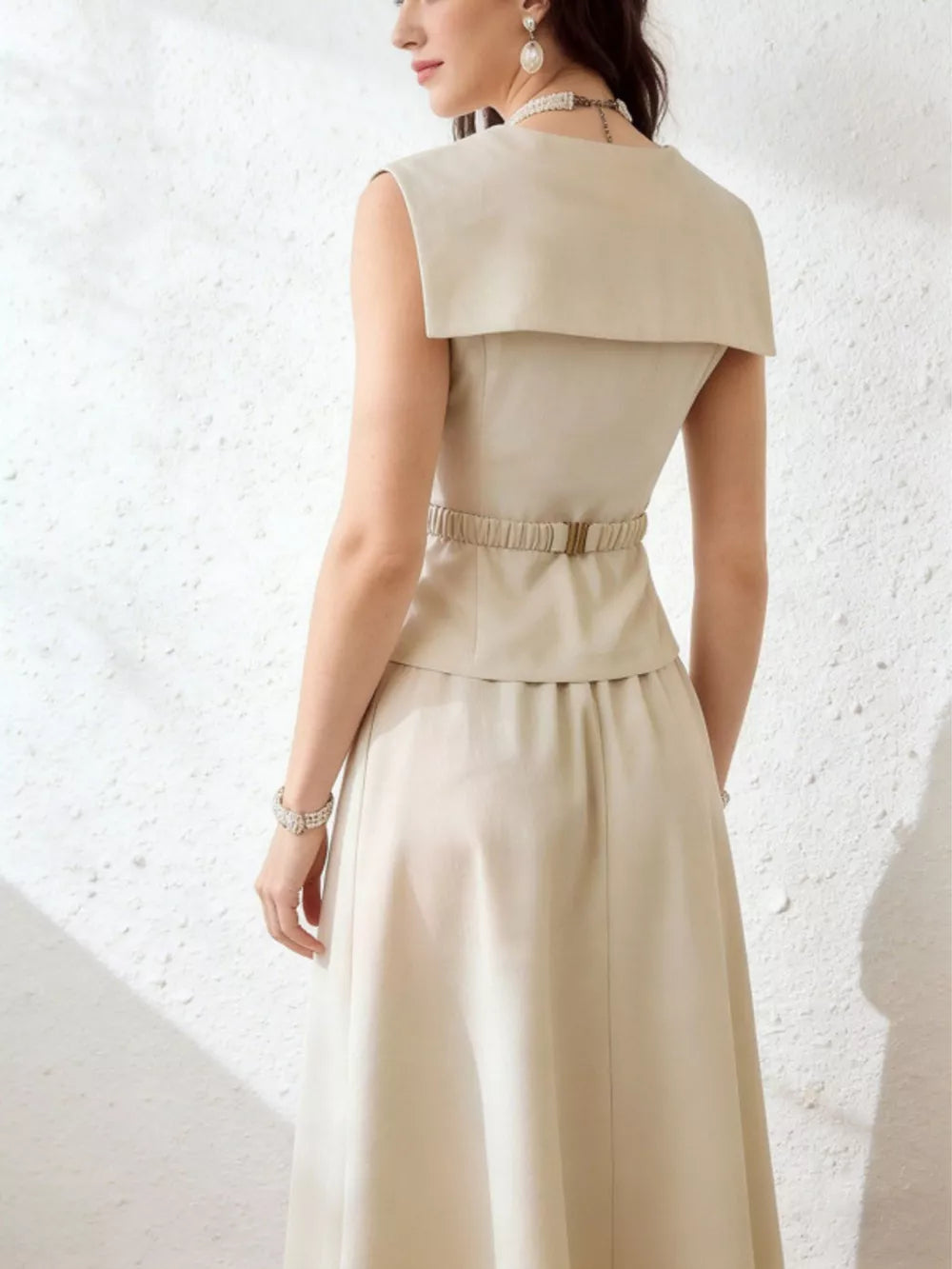 Cream V-neck peplum top and midi skirt set with a belted waist and wide collar detail.