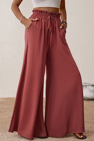 Crimson palazzo trousers with paperbag waist, drawstring, and wide legs.