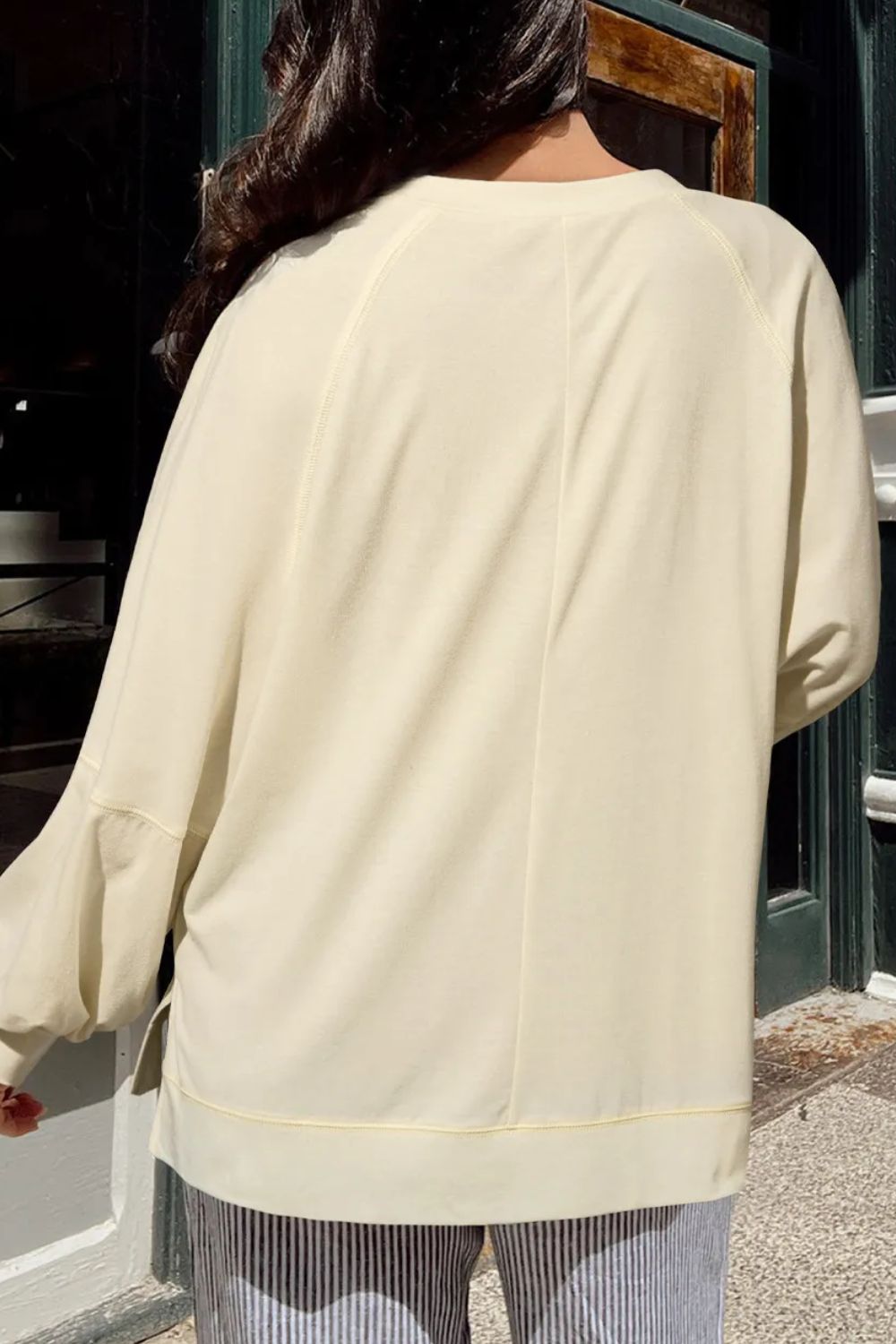 Pastel yellow gathered sleeve v-neck blouse with subtle stitching details.