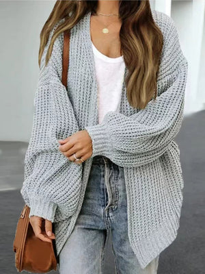 Gray chunky knit cocoon cardigan with balloon sleeves and open front, styled with jeans.