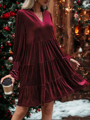 Burgundy velvet tiered mini dress with V-neck and smocked cuffs.